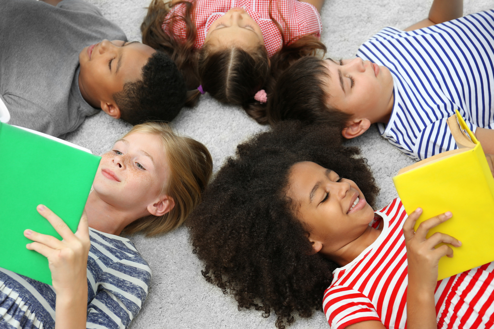 Cute Kids Lying on Carpet Reading Books at Home